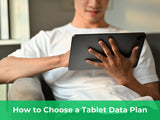 Person holding a tablet on a sofa while choosing a tablet data plan