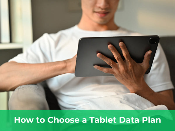 Person holding a tablet on a sofa while choosing a tablet data plan