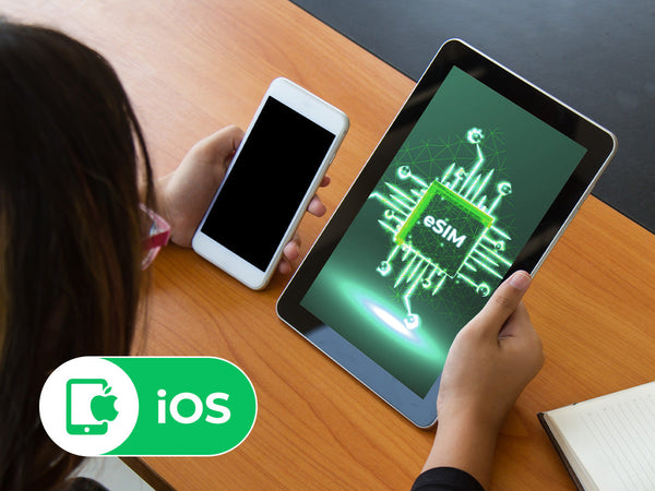 A person holding a tablet displaying a glowing green eSIM chip graphic, with an 'iOS' logo indicating compatibility for Apple devices.