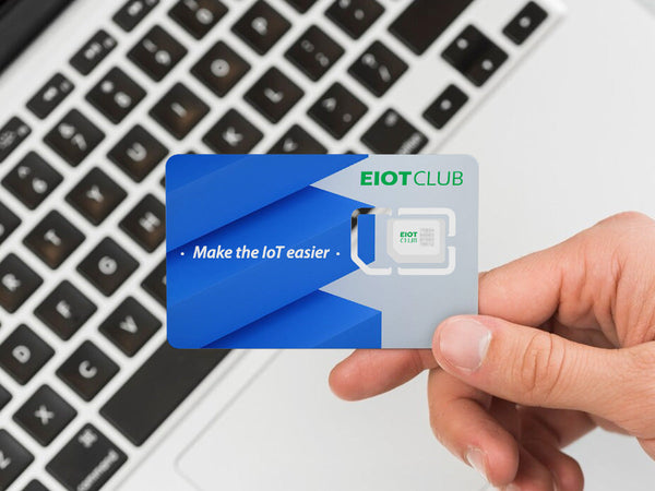 An EIOTCLUB SIM card for IoT devices, held over a laptop to represent easy activation and management for connecting your technology.