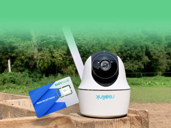 A Reolink security camera and an EIOTCLUB SIM card displayed on a wooden post outdoors.