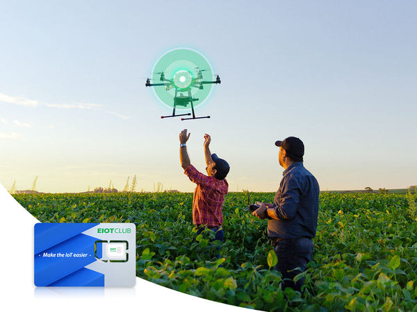 Two men operating a drone over a lush crop field, with an EIOTCLUB SIM card displayed in the foreground