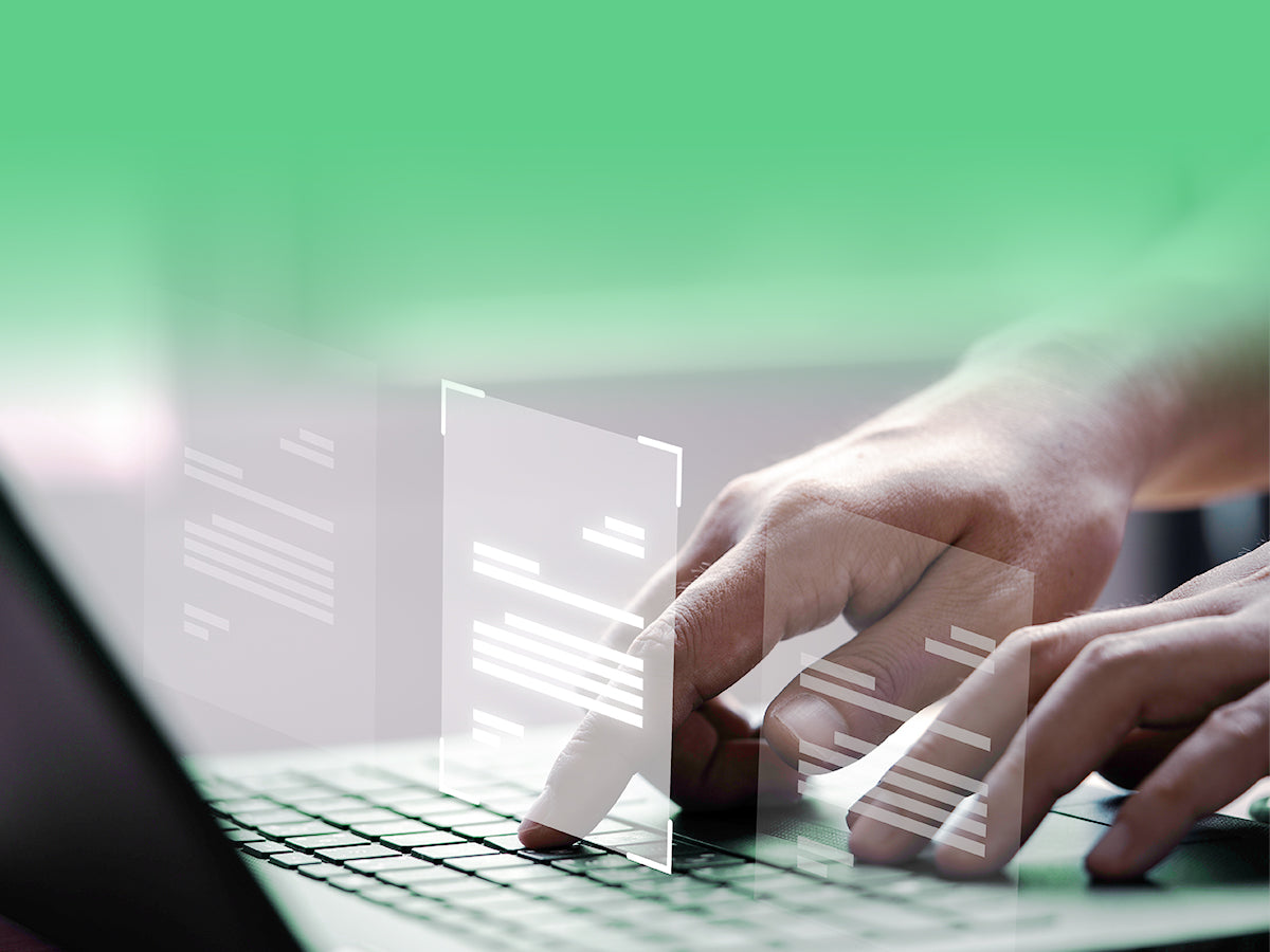 Close-up of hands typing on a laptop, with digital interface windows floating above the keyboard.